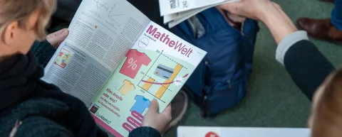 Blick über die Schuler bei einer Leserin, die in der Zeitschrift "mathematik lehren" blättert.